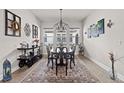 Bright dining room with an elegant chandelier, large windows, and a decorative rug adding a touch of sophistication at 4195 Barletta Ct, Wesley Chapel, FL 33543