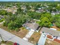 Aerial view of a single-Gathering home with a driveway, surrounded by lush green trees at 4435 Lamson Ave, Spring Hill, FL 34608
