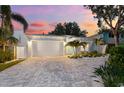 Charming single story home with nicely landscaped yard and brick driveway under a colorful sunset sky at 475 Crystal Beach, Crystal Beach, FL 34681