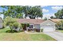 Charming home with a manicured lawn, a two-car garage, and beautiful landscaping, creating excellent curb appeal at 4915 Fort Peck Rd, New Port Richey, FL 34655