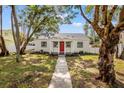 Inviting home with mature trees, red front door, and walkway at 5724 Dr Martin Luther King Jr N St, St Petersburg, FL 33703