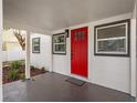 Welcoming front porch with a striking red door, and gray trim at 5724 Dr Martin Luther King Jr N St, St Petersburg, FL 33703