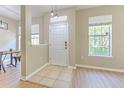 Inviting entryway featuring neutral walls, tile flooring, and natural light from a window, open to a dining area at 6782 Breezy Palm Dr, Riverview, FL 33578