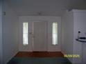Welcoming foyer featuring a white front door, side windows, and neutral walls at 7224 Ryman Loop, Zephyrhills, FL 33540