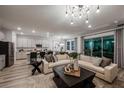 Spacious living room with modern lighting, comfortable sofas, and an open view to the kitchen at 10009 Surrey Rose Dr, San Antonio, FL 33576