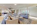 Inviting living room with neutral tones, decorative rug, and a striking staircase at 1089 Virginia St, Dunedin, FL 34698