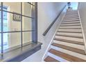 Clean and bright staircase with hardwood treads and white risers, complemented by a dark handrail at 1111 Normandy Trace Rd # 1111, Tampa, FL 33602
