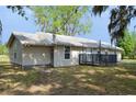 The home has neutral siding, a metal roof, and a small front porch at 11141 Rex Hunter Ln, Lithia, FL 33547