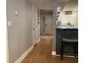 Hallway with hardwood floors that lead to the kitchen and living room area with grey walls and white trim at 120 1St E St # 104, St Petersburg, FL 33715