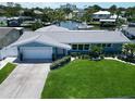 Waterfront home with a manicured lawn, beautiful landscaping, and a boat dock, perfect for enjoying waterfront lifestyle at 1769 Brookside Blvd, Largo, FL 33770