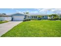 Charming home with a lush green lawn, colorful landscaping, and a welcoming entrance, showcasing curb appeal at 1769 Brookside Blvd, Largo, FL 33770