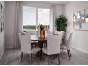 Dining area with wood table, four chairs, decorative vases and a large window at 1856 Draughton Dr, Zephyrhills, FL 33541
