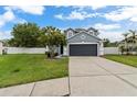 Beautiful two-story home boasts a well-manicured lawn, tree, and a paved driveway at 1948 Grenville Ct, Wesley Chapel, FL 33543