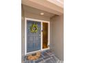 Close-up of a stylish blue front door with a decorative wreath and a charming welcome mat at 2012 Scotland Dr, Clearwater, FL 33763