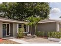 Welcoming front entrance with a blue front door, attractive landscaping, and a cozy bench at 2012 Scotland Dr, Clearwater, FL 33763