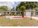 Inviting home with a fresh exterior, mature landscaping, and a driveway leading to an attached garage at 2012 Scotland Dr, Clearwater, FL 33763