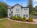 Charming two-story white home with black accents, landscaping, and well-manicured lawn at 2306 Trelain S Dr, St Petersburg, FL 33712