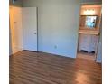 Bedroom with warm wood flooring leading to an ensuite bathroom at 2720 Sand Hollow Ct # 156A, Clearwater, FL 33761