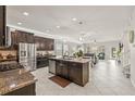 Spacious kitchen with stainless steel appliances and dark cabinets, opens to a dining area and a staircase at 3212 Calvano Dr, Land O Lakes, FL 34639
