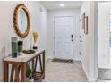 Inviting foyer with a marble topped console table, stylish decor, and neutral tile flooring at 3327 Thistle Bank Ct, Plant City, FL 33565