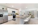 Modern kitchen with stainless steel appliances, granite countertops, and an adjacent dining area at 3529 Thistle Bank Ct, Plant City, FL 33565