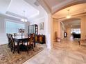 Formal dining room with a large window, chandelier, and classic furnishings at 3643 Arbor Chase Dr, Palm Harbor, FL 34683
