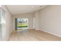 Bright living room with hardwood floors and sliding glass doors to the backyard at 37155 Sagemoor Dr, Zephyrhills, FL 33541