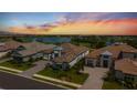 Stunning aerial view of luxury homes overlooking a serene lake and golf course at sunset, with meticulously landscaped lawns at 3888 Santa Caterina Blvd, Bradenton, FL 34211