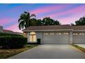 Charming single-story home with a two-car garage, manicured landscaping, captured under a beautiful sky at 4032 Salem Square Ct, Palm Harbor, FL 34685