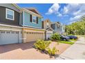Street view of colorful townhomes showcasing brick driveways, attached garages, and lush landscaping at 4316 Sailplane Ct, Wesley Chapel, FL 33545