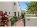 Charming home entrance with an iron gate leading to a paved walkway and lush greenery at 4941 Bayshore Blvd, Tampa, FL 33611