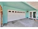 Spacious garage area featuring a white garage door and an entrance to the home at 6530 Manila Palm Way, Apollo Beach, FL 33572