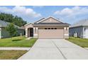 Inviting single-story home with a manicured lawn and a neutral color palette, showcasing its curb appeal at 6623 Northhaven Ct, Riverview, FL 33578