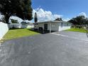 Features a backyard with a covered patio and asphalt parking area, ideal for gatherings at 7102 Reindeer Rd, Tampa, FL 33619