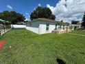 Shows the home's clean, white exterior and neatly kept lawn, framed by a modern fence at 7102 Reindeer Rd, Tampa, FL 33619