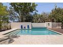 Backyard swimming pool surrounded by tile and a privacy wall, with a wooden deck at 7235 Sunshine S Dr, St Petersburg, FL 33705