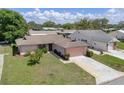 Charming single-story home with attached garage, manicured lawn, and established landscaping on a sunny day at 10820 Hachita Dr, Port Richey, FL 34668