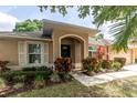 Inviting home entrance showcasing a covered porch and colorful landscaping at 11416 Wellman Dr, Riverview, FL 33578