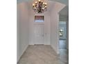 Bright entryway featuring tile floors, a decorative chandelier, and a view of an adjacent room at 12055 Cardinal Flower Dr, Riverview, FL 33579