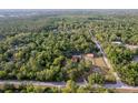 Majestic aerial view of a peaceful property with a charming home, a barn and refreshing pool surrounded by verdant trees at 12311 Oakwood Dr, Hudson, FL 34669