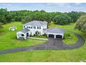 Aerial view of two-story white home with metal roof, long driveway, and large lot at 13711 Lussier Ln, Spring Hill, FL 34610