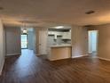 Open living space with wood-look vinyl floors, neutral paint, and white kitchen with breakfast bar at 13742 14Th St, Dade City, FL 33525