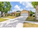 Charming home featuring mature landscaping, a well-manicured lawn, and an attached two-car garage at 1426 Buckner Rd, Valrico, FL 33596