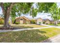 Charming home featuring mature landscaping, a well-manicured lawn, and an attached two-car garage at 1426 Buckner Rd, Valrico, FL 33596