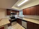 Kitchen with stainless steel appliances, granite counters, dark wood cabinets, and modern backsplash at 14446 Reuter Strasse Cir # 3, Tampa, FL 33613
