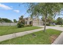 Single-story home with a well-manicured lawn, a two-car garage, and neutral-toned exterior paint at 17516 Bright Wheat Dr, Lithia, FL 33547