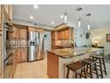 Modern kitchen with stainless steel appliances, granite countertops, tiled floor, and breakfast bar seating at 2667 Aspen Ct, Palm Harbor, FL 34684