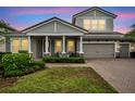 Charming two-story home with a well-manicured lawn, covered porch, and two car garage at 3326 Barbour Trl, Odessa, FL 33556