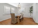 Traditional dining room boasts wood floors, modern lighting, and large windows for natural light at 39542 Friends Ave, Zephyrhills, FL 33540