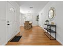 Inviting entryway with hardwood floors and stylish decor, leading to the dining area, showcasing a modern aesthetic at 39542 Friends Ave, Zephyrhills, FL 33540